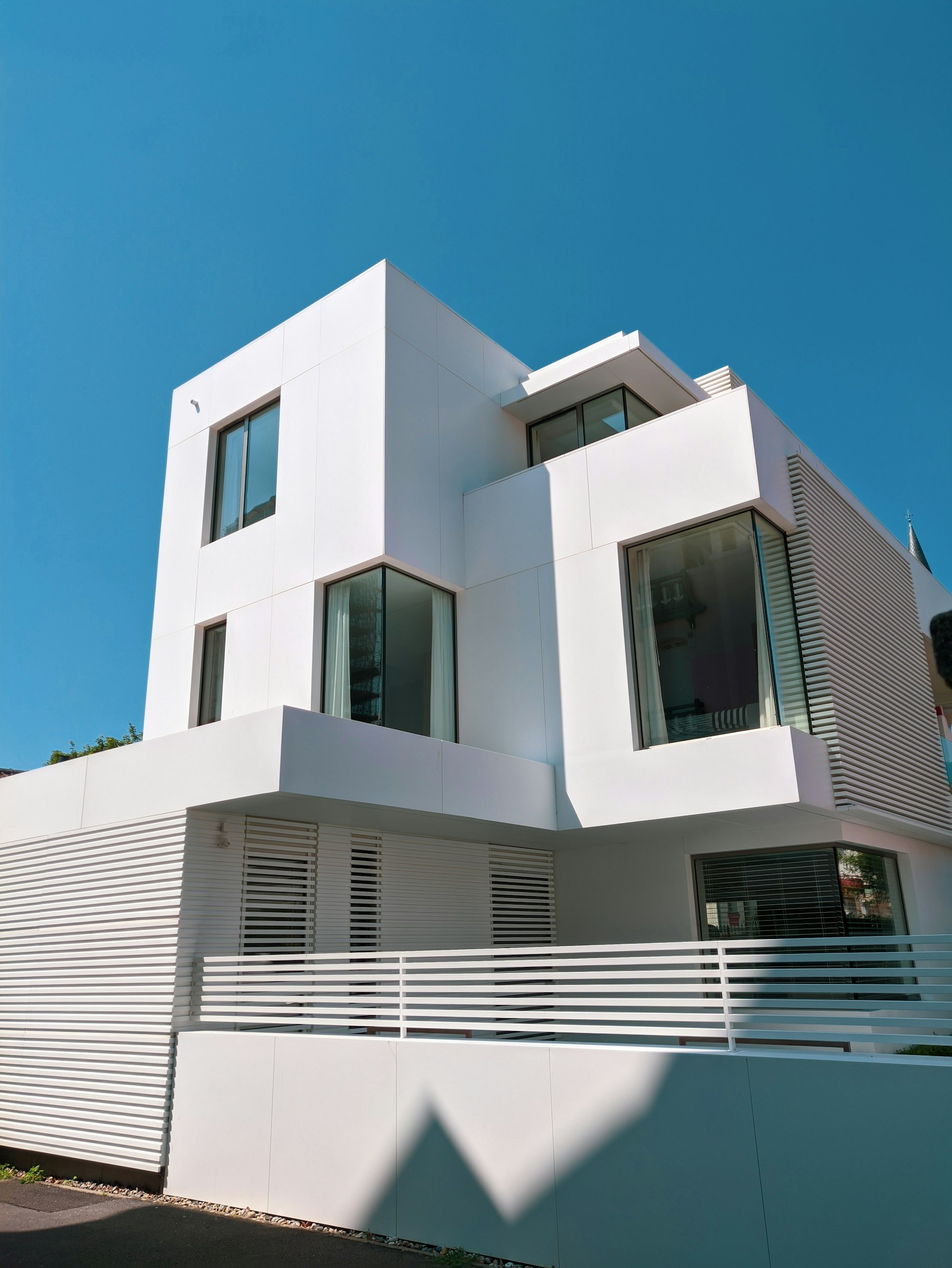 Maison contemporaine en béton blanc sous un ciel bleu