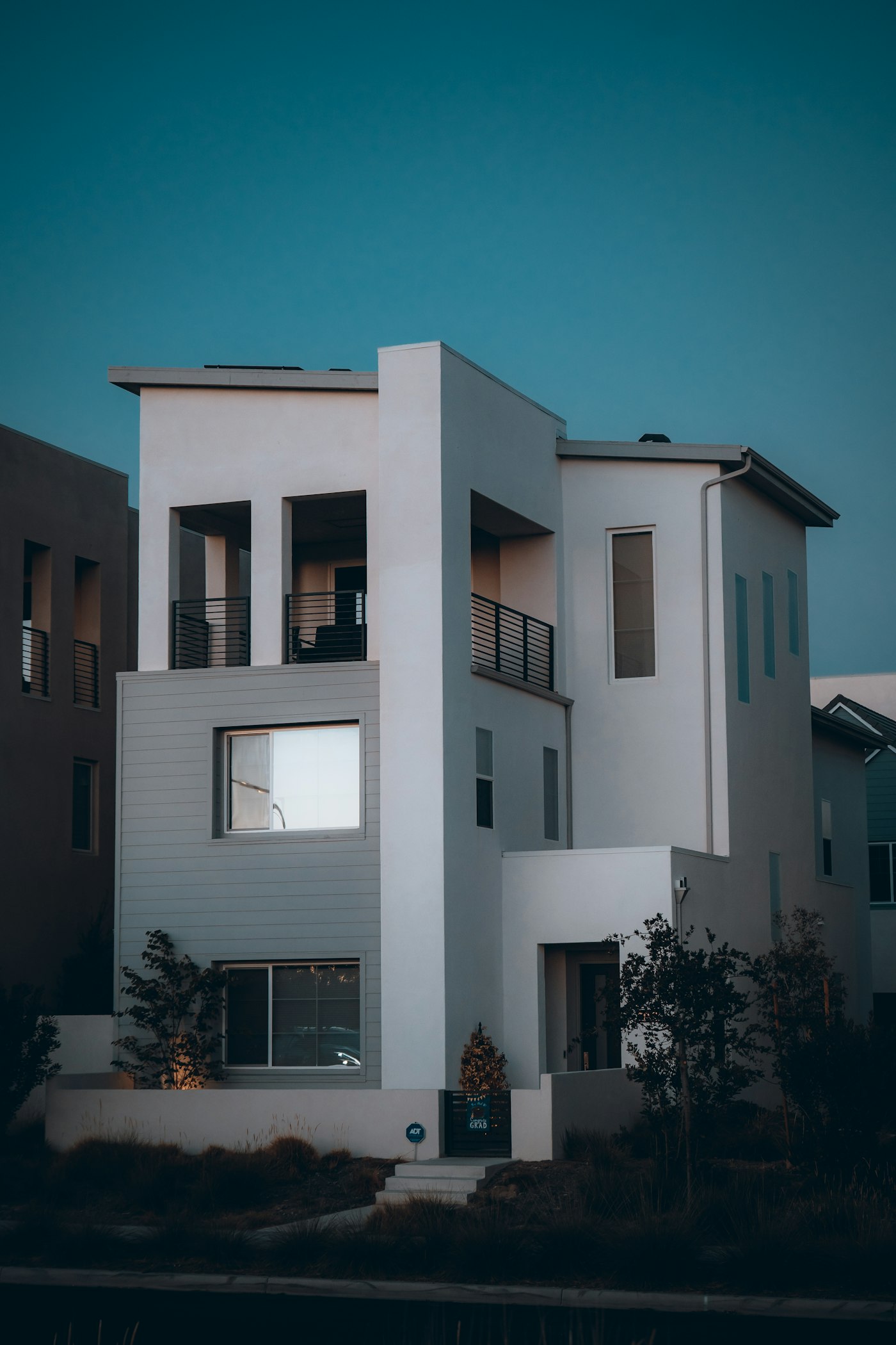 Maison moderne blanche de trois niveaux avec bardage gris